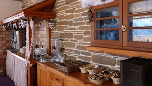 Una cocina rústica con paredes de piedra, armarios de madera y una encimera de madera con cestas y frascos.