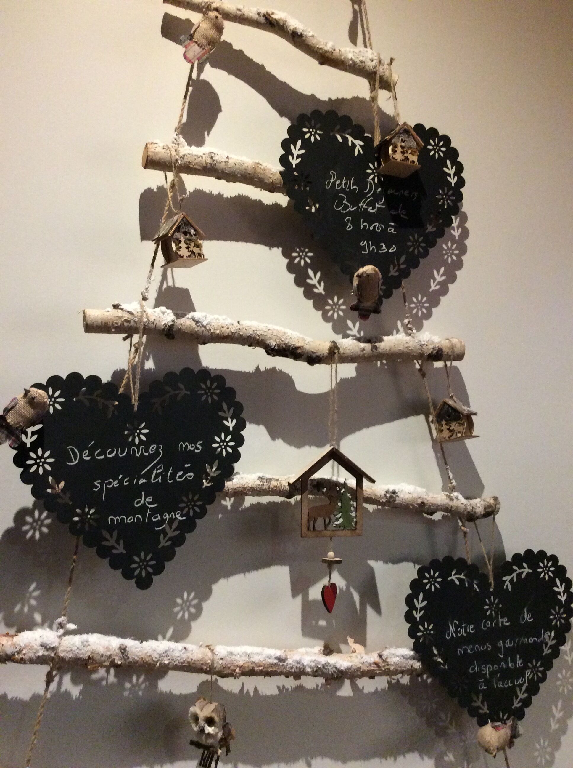Un mur décoratif orné de panneaux en forme de cœur et de nichoirs.