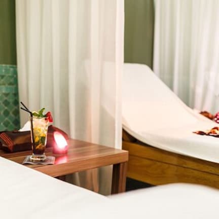 A hotel room with a bed, a bedside table, and a mirror.