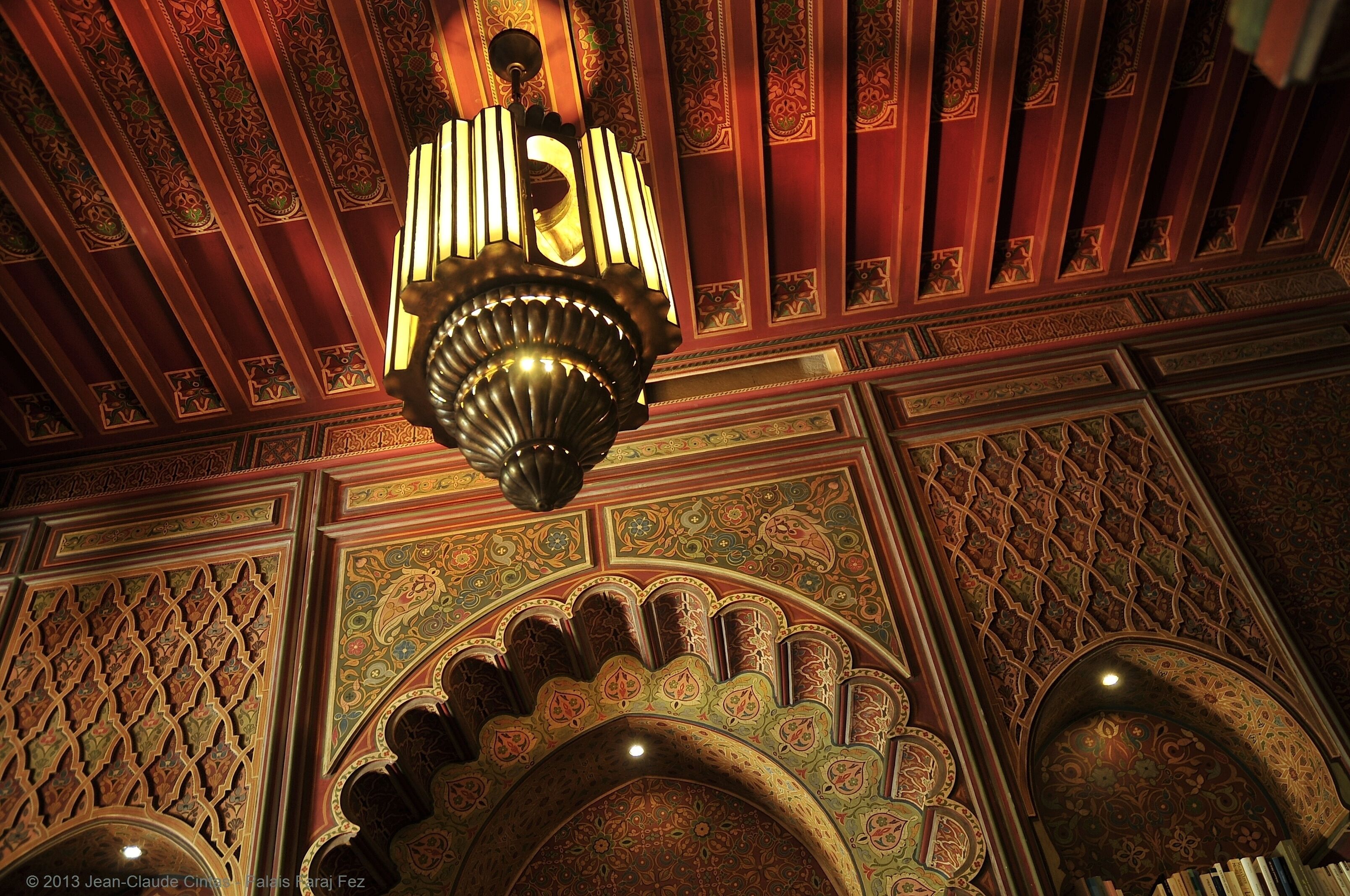 An ornate ceiling with intricate patterns and a chandelier.
