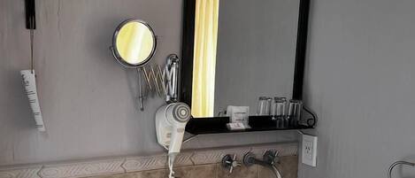 Un baño con inodoro, lavamanos y perchero para toallas.