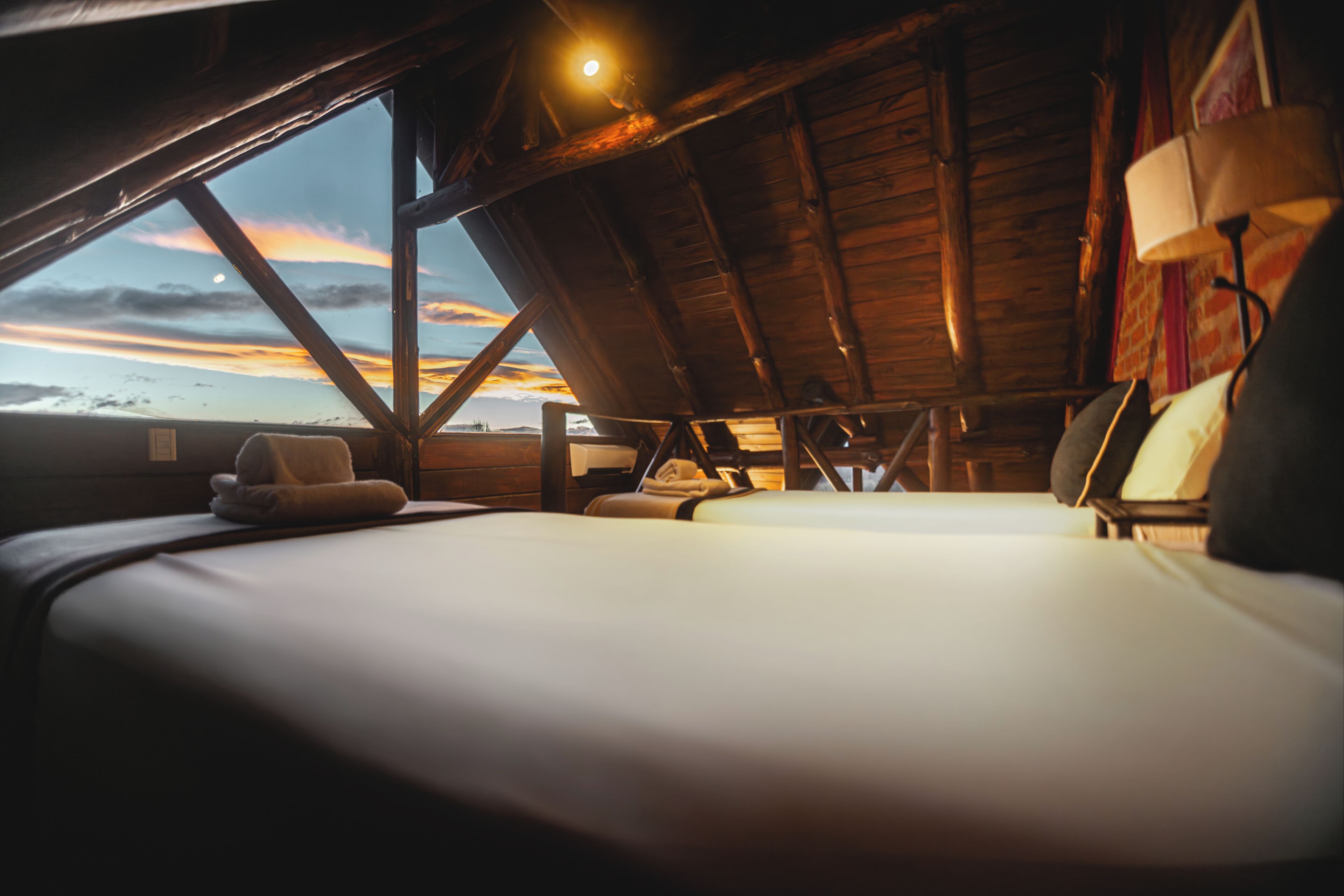 Una habitación con una cama, una ventana y una lámpara.