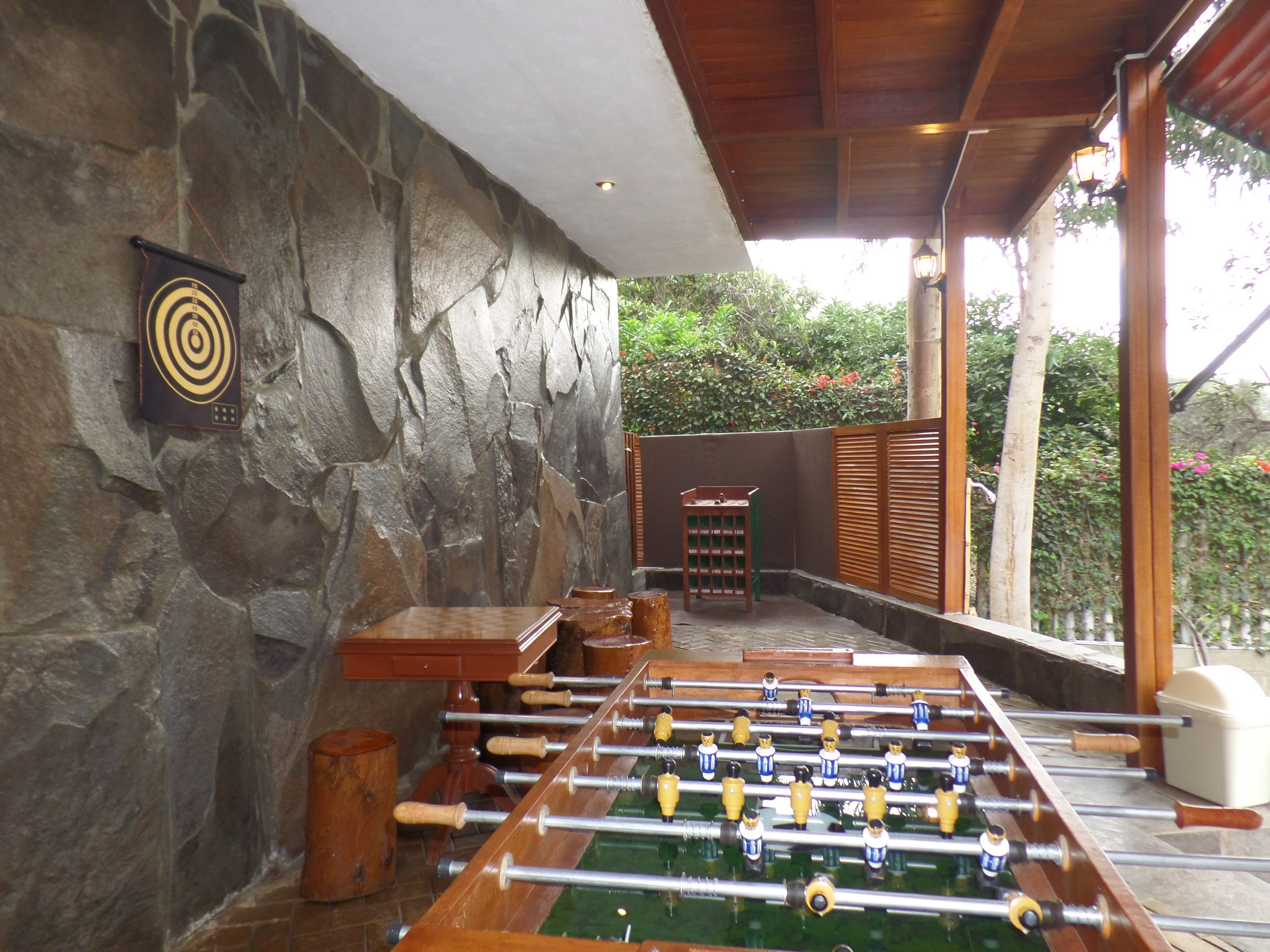 A foosball table in a room with stone walls and a wooden ceiling.