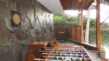 A foosball table in a room with stone walls and a wooden ceiling.