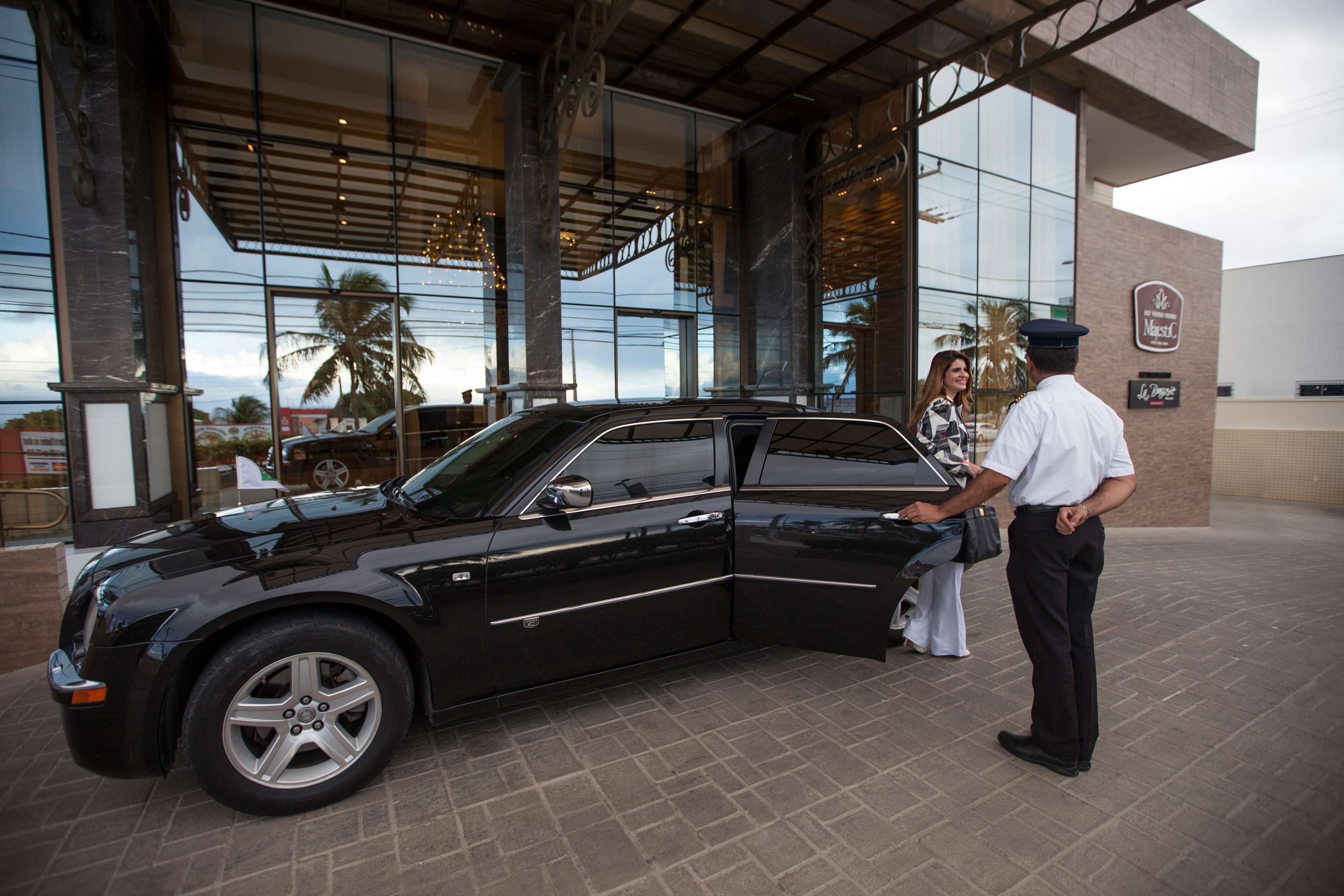 A black SUV parked in front of a building with large glass windows and a sign that reads "Marriott."