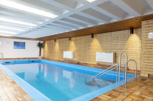 Una piscina cubierta, tumbonas