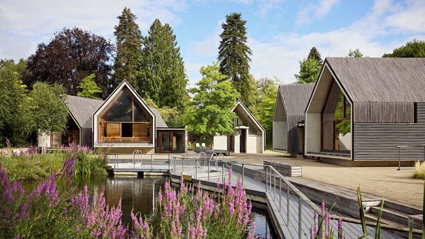 A modern building complex with a wooden deck and a pond with purple flowers. - Dorint Parkhotel Jordanbad Biberach an der Riß (Biberach an der Riss)
