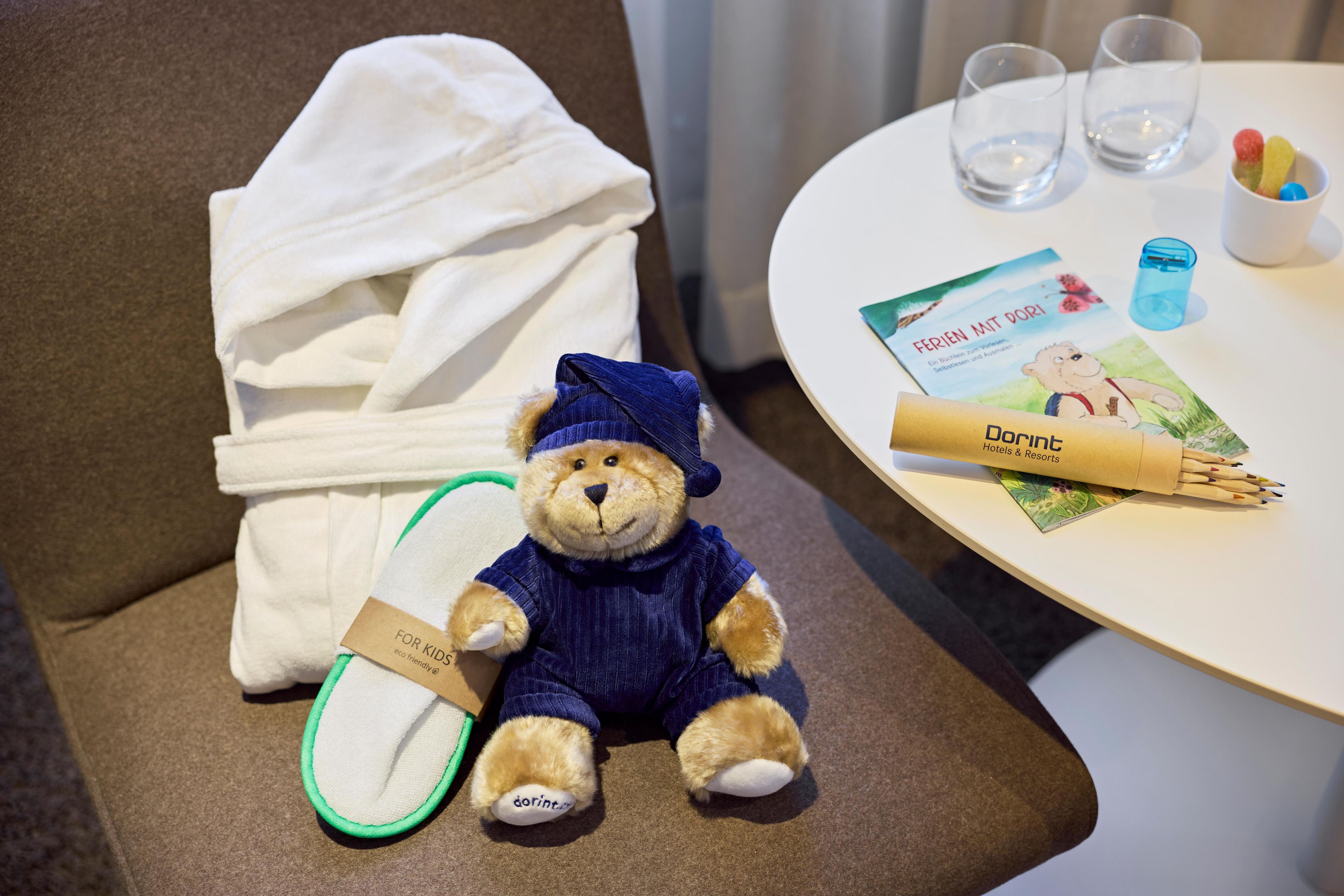 Un jouet en peluche, une serviette, une brochure et des lunettes sur une table.