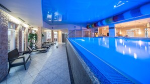 A swimming pool area with lounge chairs and a spa sign.