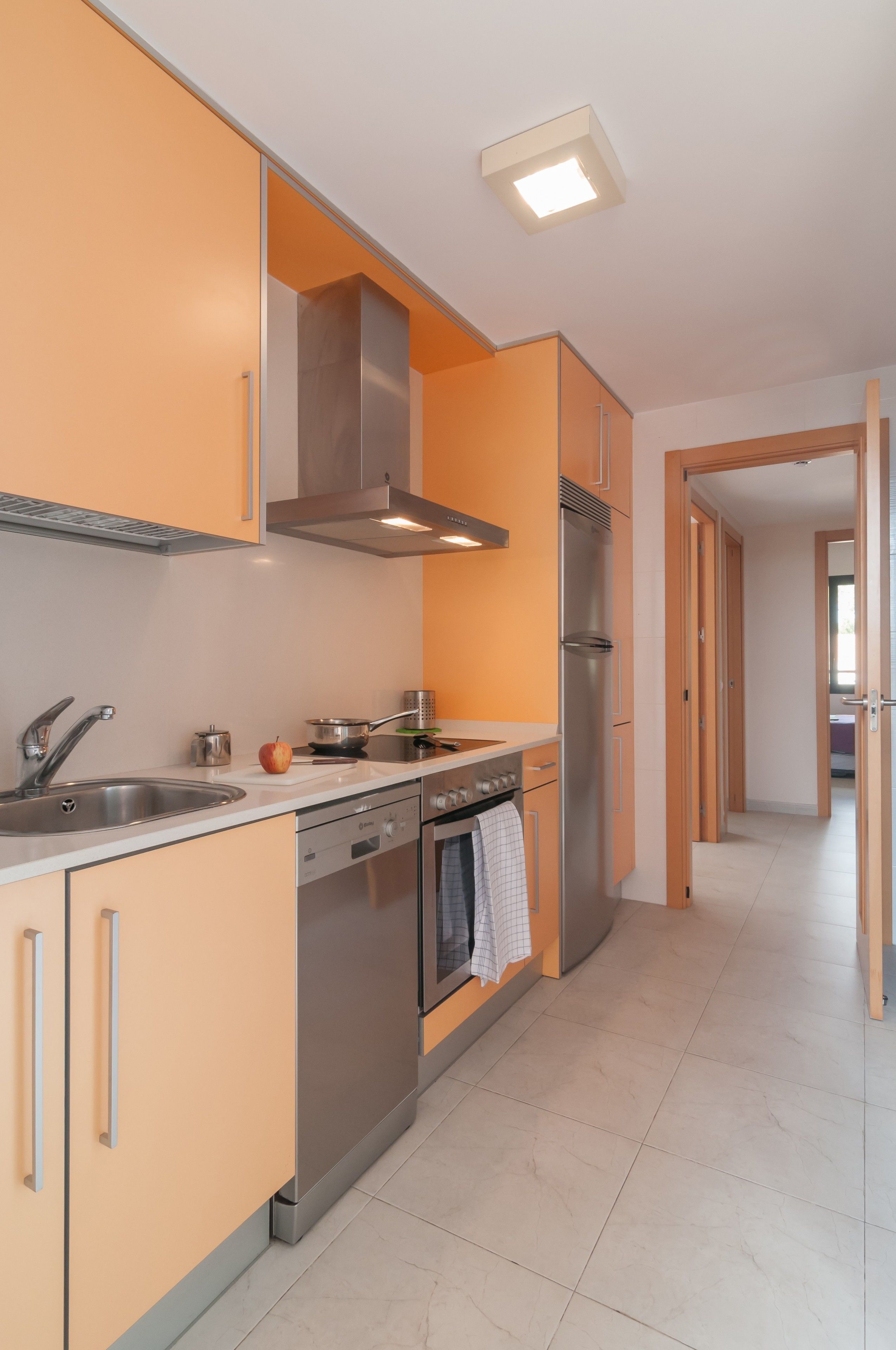A modern kitchen with stainless steel appliances, a built-in oven, and a dishwasher.