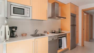 Een moderne keuken met een magnetron, koffiezetapparaat, spoelbak en roestvrijstalen apparatuur.