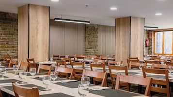 A dining area with multiple tables and chairs, stone walls, and a fire extinguisher.