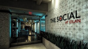 A modern interior with a sign reading "The Social at Eilan" and a no cash accepted sign.