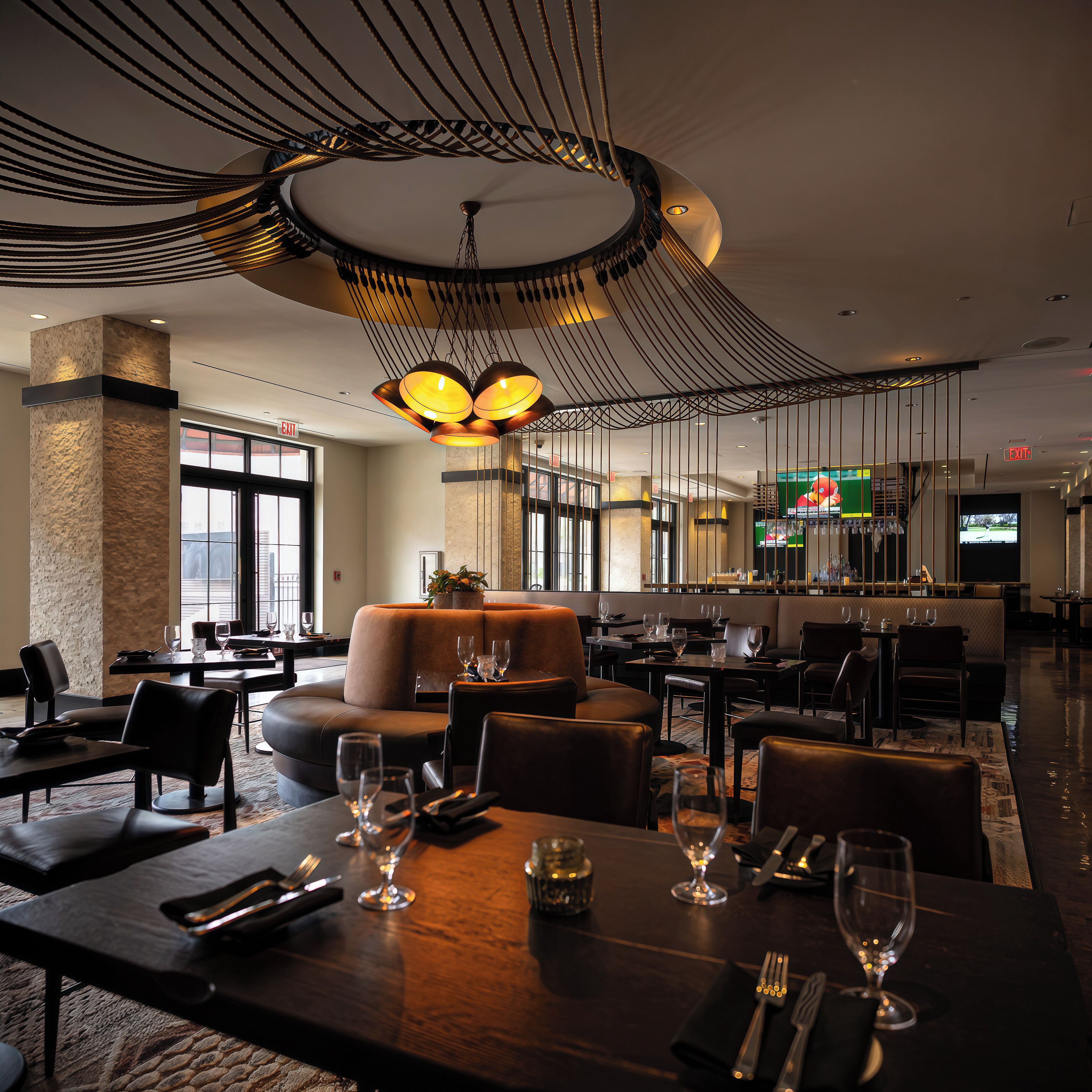 Un restaurant au décor moderne, avec un espace central comprenant un canapé et plusieurs tables entourées de chaises.
