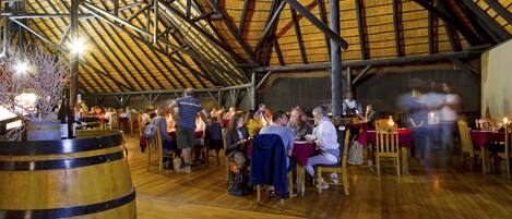 An indoor dining area with wooden tables and chairs, a large barrel labeled "BEYERSKLOO", and a high wooden ceiling.