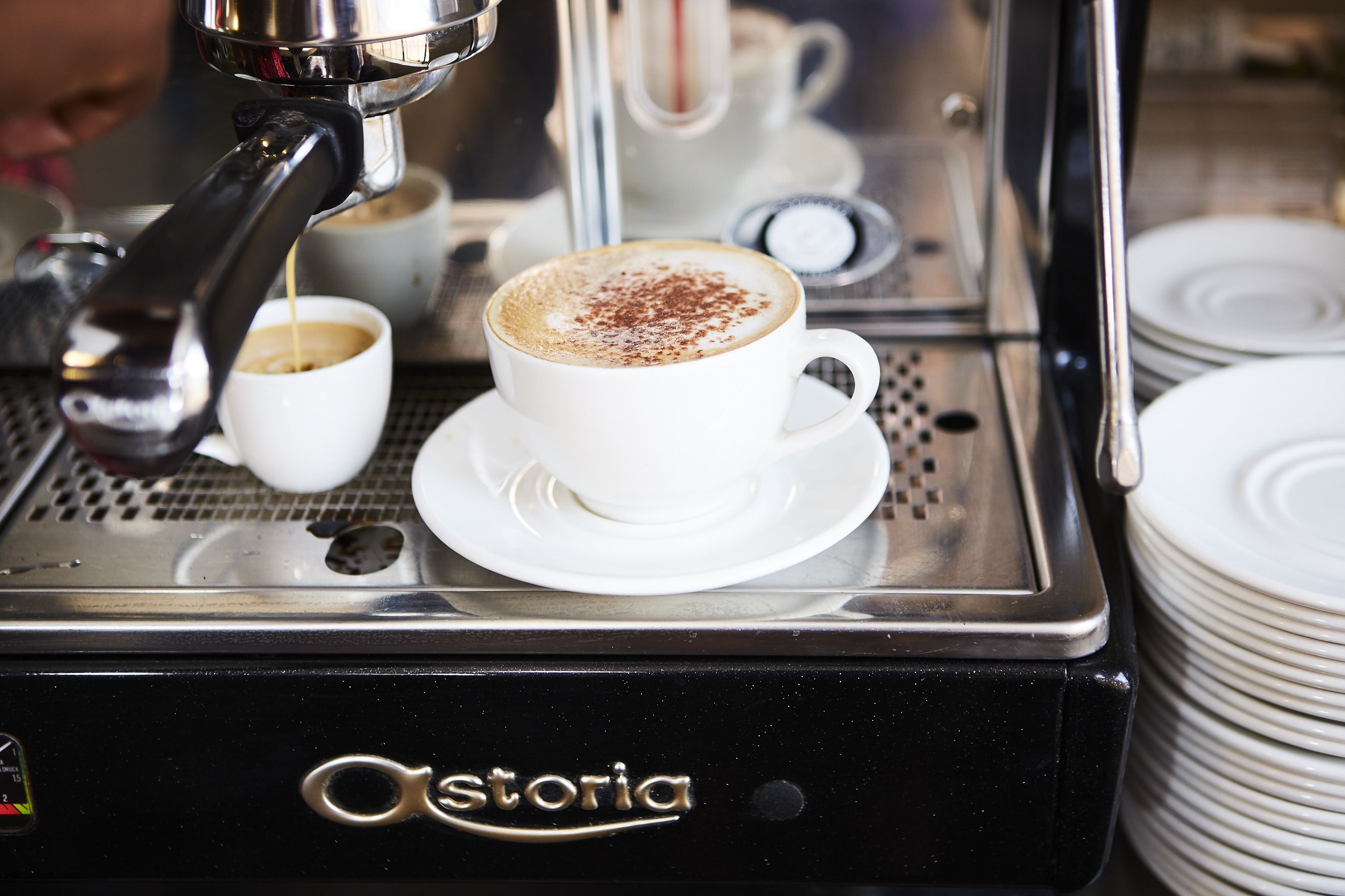 A coffee machine with a cup of coffee on the counter.