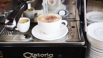 Una cafetera con una taza de café sobre la encimera.