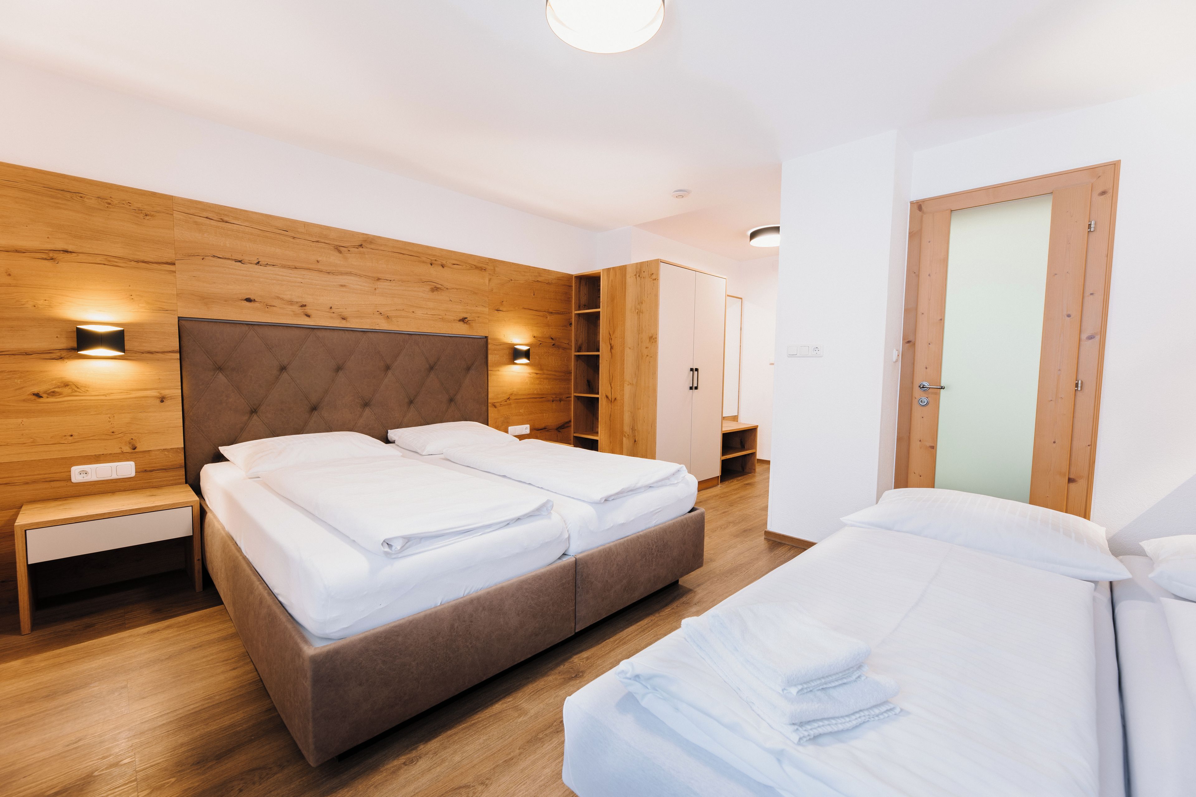 A modern bedroom with a large bed, bedside tables, and built-in shelving.