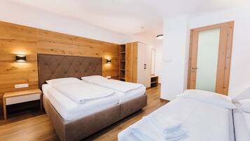A modern bedroom with a large bed, bedside tables, and built-in shelving.