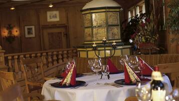 A dining area with a round table set for a meal, surrounded by wooden chairs.