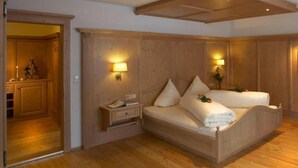 Un dormitorio con paneles de madera, una cama, mesitas de noche y lámparas fijadas a la pared.