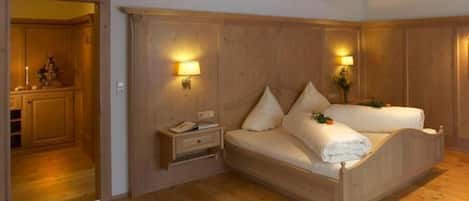 Un dormitorio con paneles de madera, una cama, mesitas de noche y lámparas fijadas a la pared.