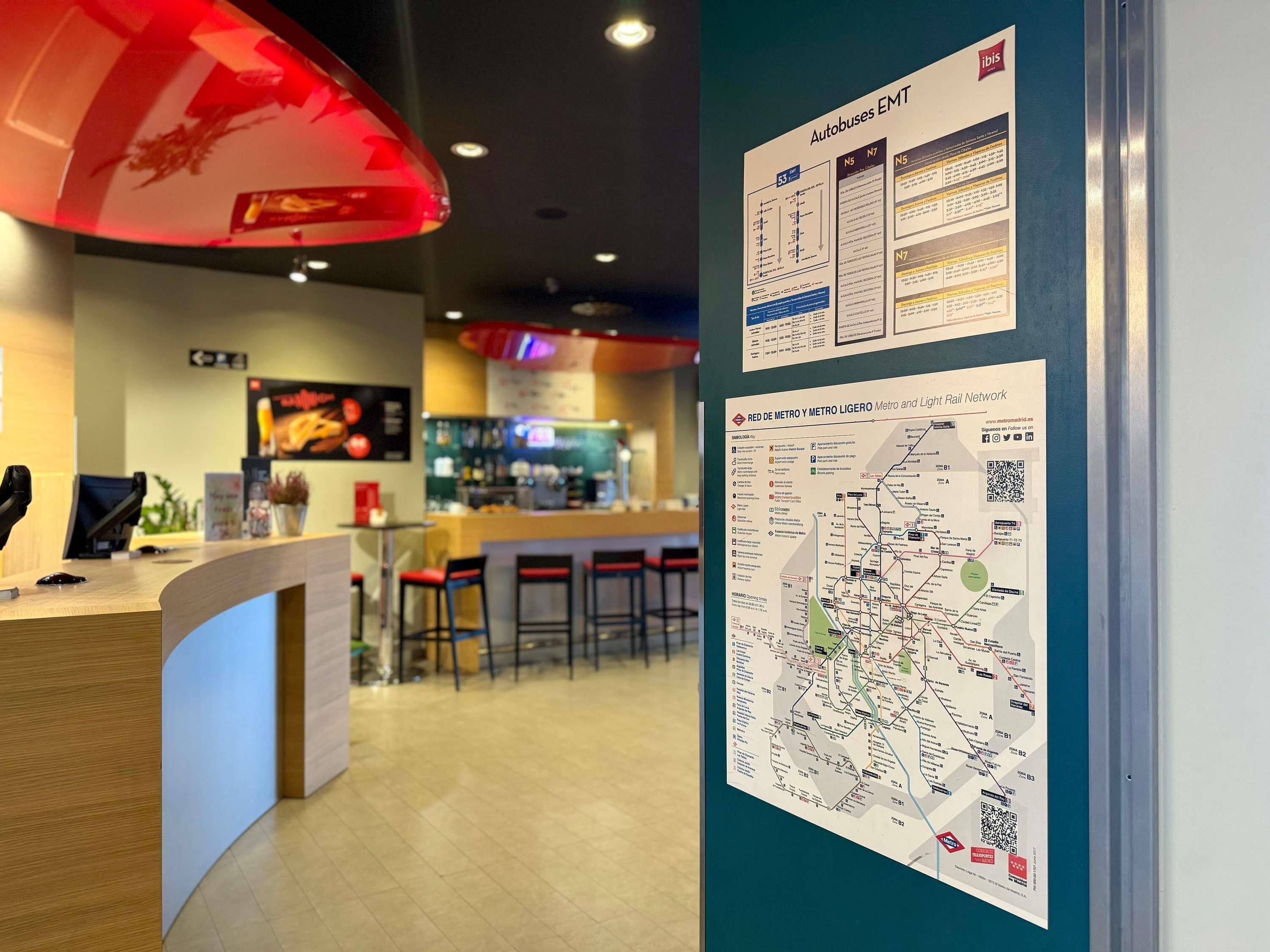 Un espace bar moderne avec un comptoir, des tabourets et un luminaire rouge suspendu au plafond.