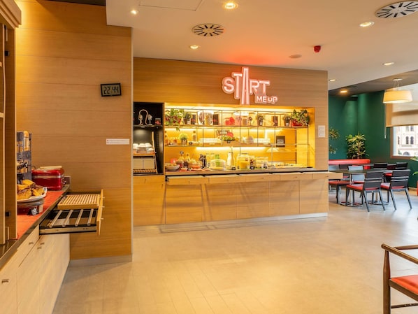 Un café moderno con un mostrador de madera, un reloj y un letrero que dice "START MEUP".
