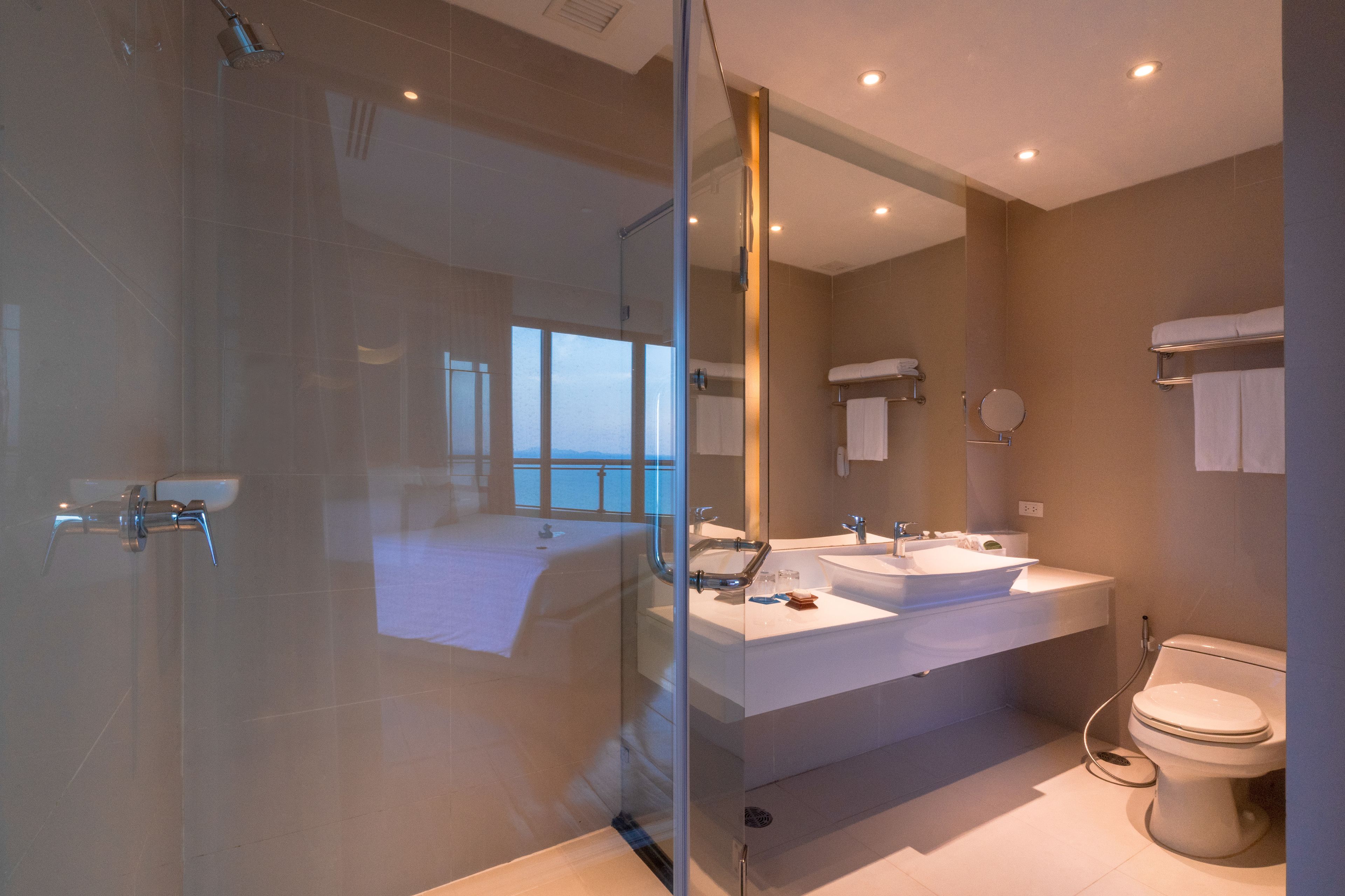 A modern bathroom with a glass-enclosed shower, dual sinks, and a toilet.