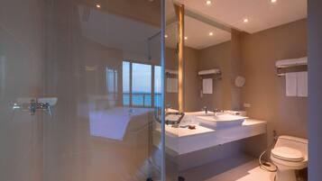A modern bathroom with a glass-enclosed shower, dual sinks, and a toilet.