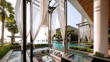 A luxurious pool area with a seating area, clear views of the pool, and a modern architectural design.