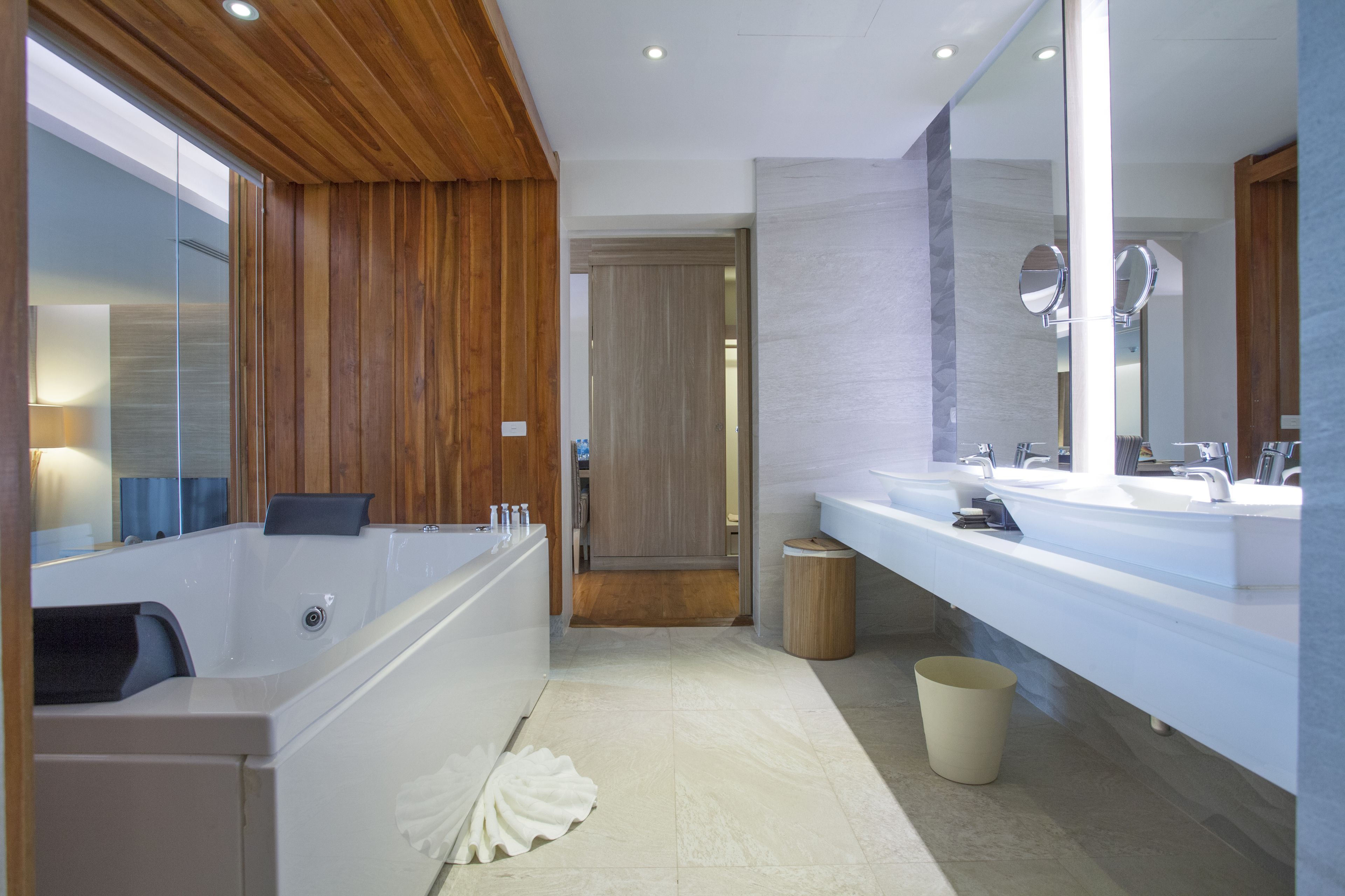 Ein modernes Badezimmer mit einer Badewanne, zwei Waschbecken und einem großen Spiegel.