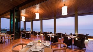 Un restaurant amb vistes al mar, sòls de fusta i lluminàries modernes.