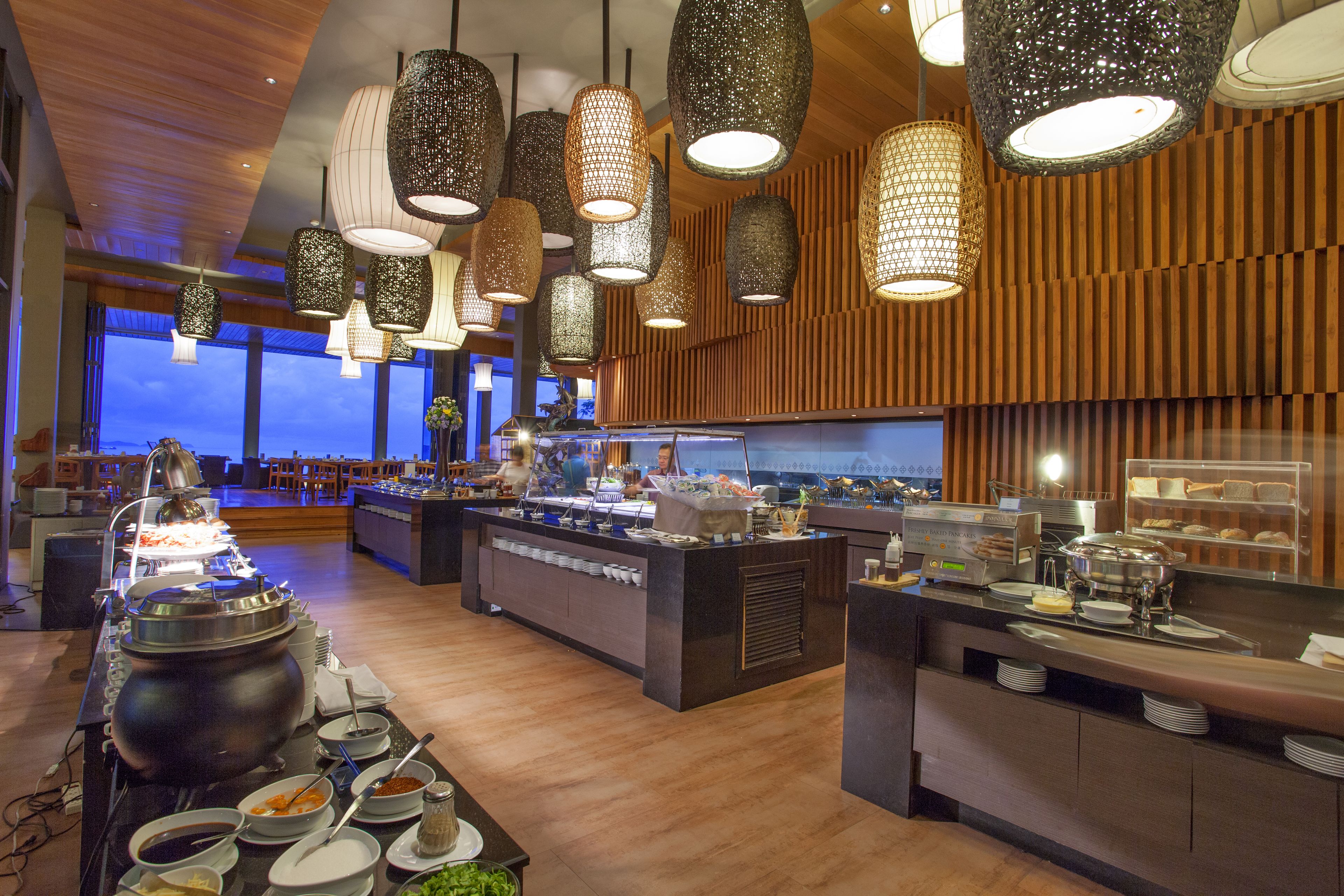 Un espace buffet comprenant plusieurs points de service, un grand récipient et une variété de plats.