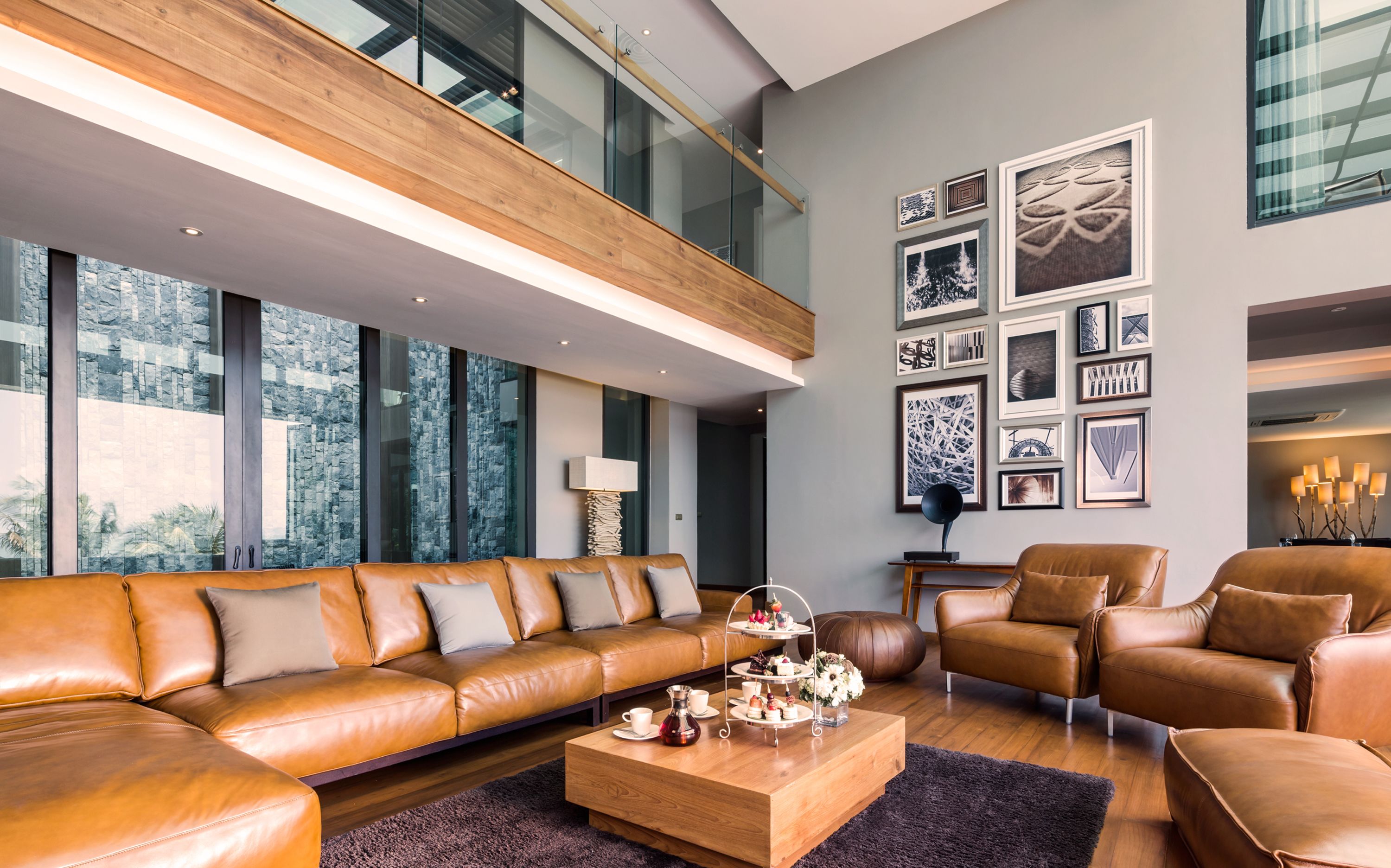 A modern living room with a leather sofa, a coffee table, and a bookshelf.