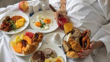 A breakfast spread with various dishes and a glass of orange juice.