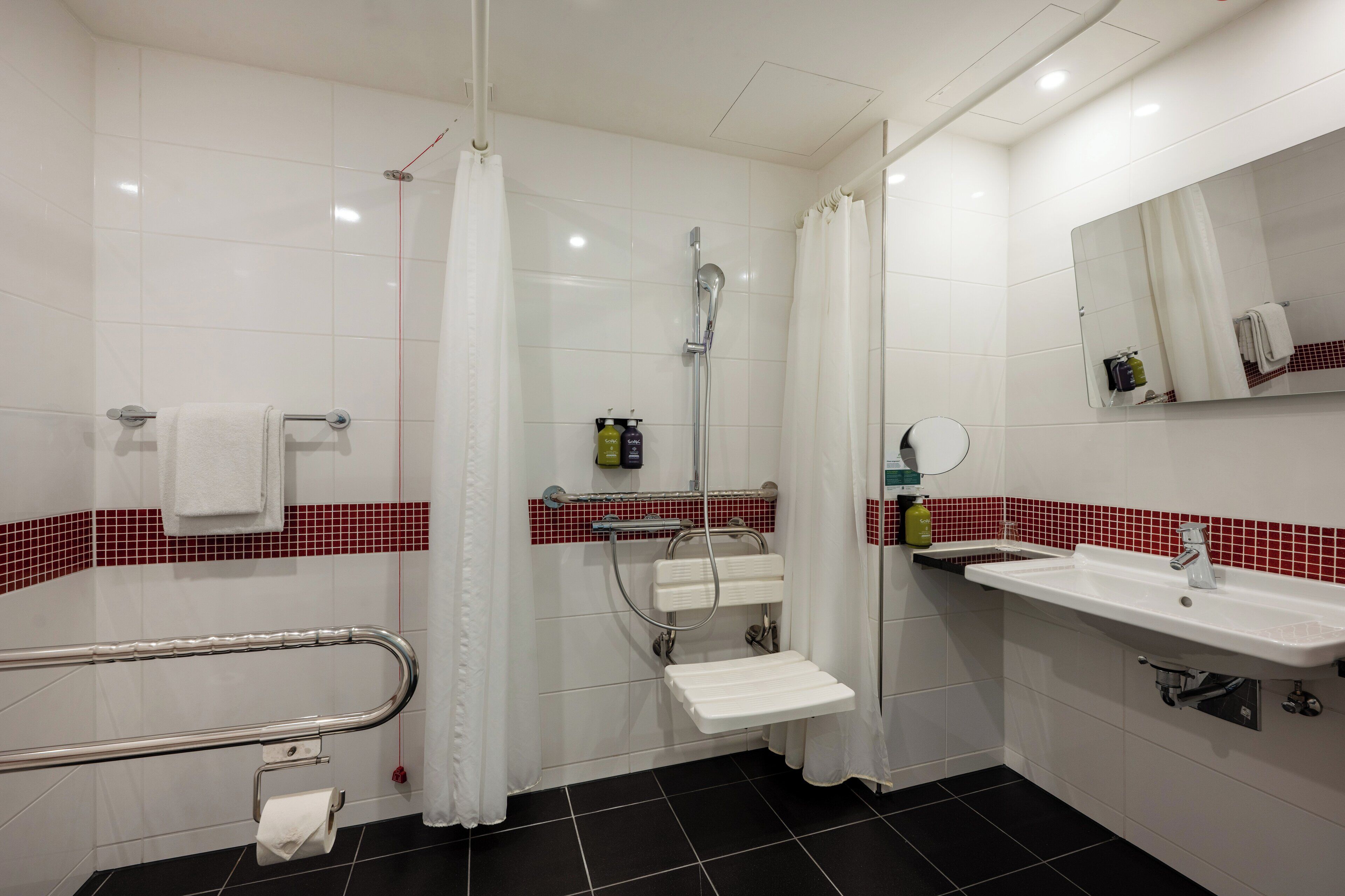 A modern bathroom with a shower, toilet, and sink.