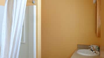 Un baño con ducha, inodoro y lavamanos.