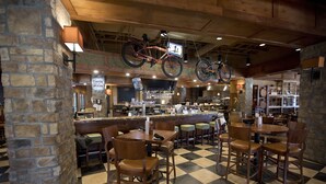 Un restaurante con piso a cuadros, muebles de madera y bicicletas colgadas del techo.