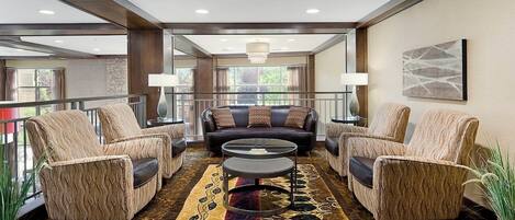 A spacious lounge area with a sofa set, two armchairs, and a coffee table.