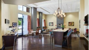 Eine geräumige Hotelhalle mit einer langen Rezeption, einer Sitzecke und einer großen Kronleuchter.