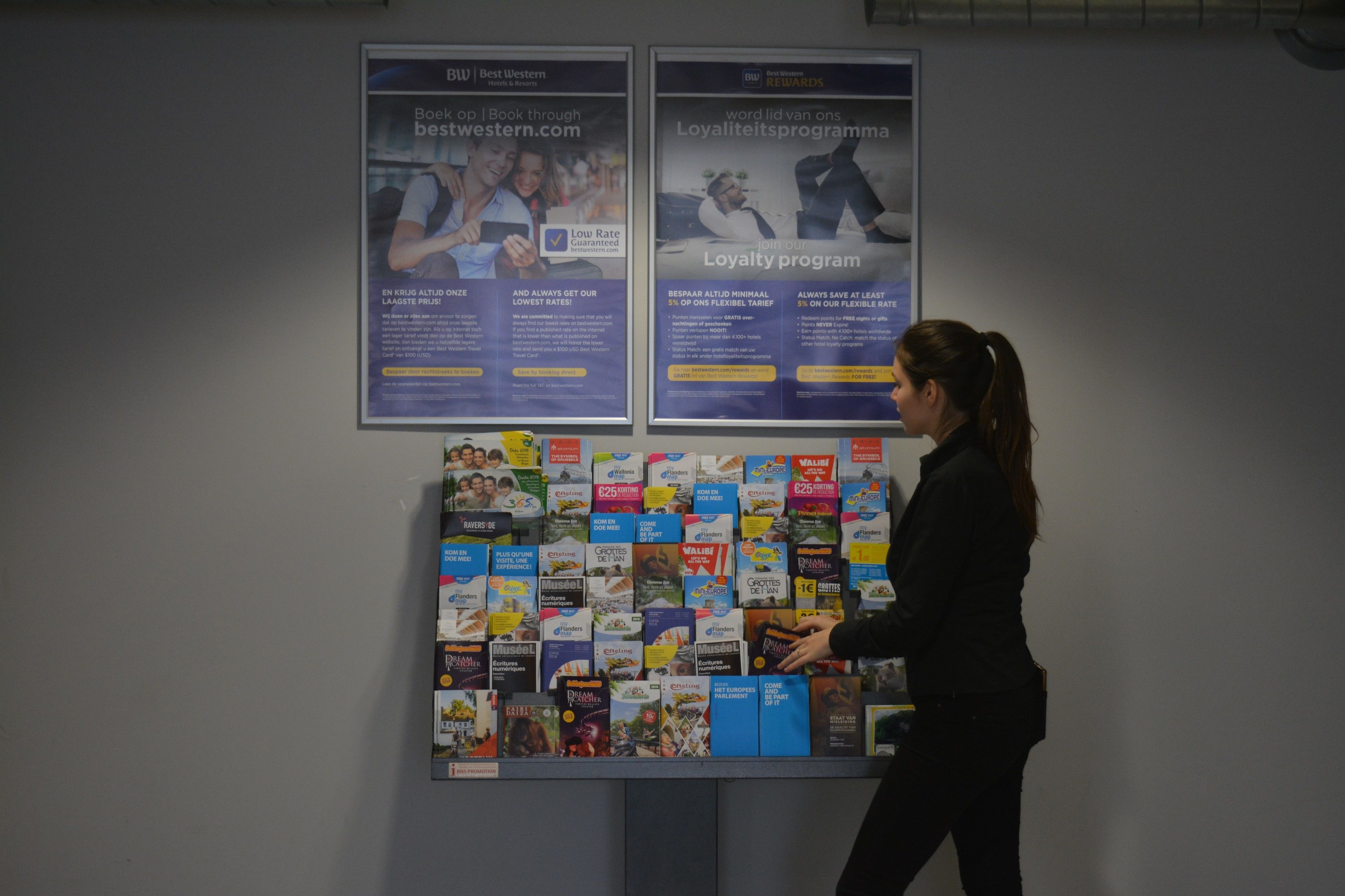 A woman browsing through a display of books at a bookstore.
