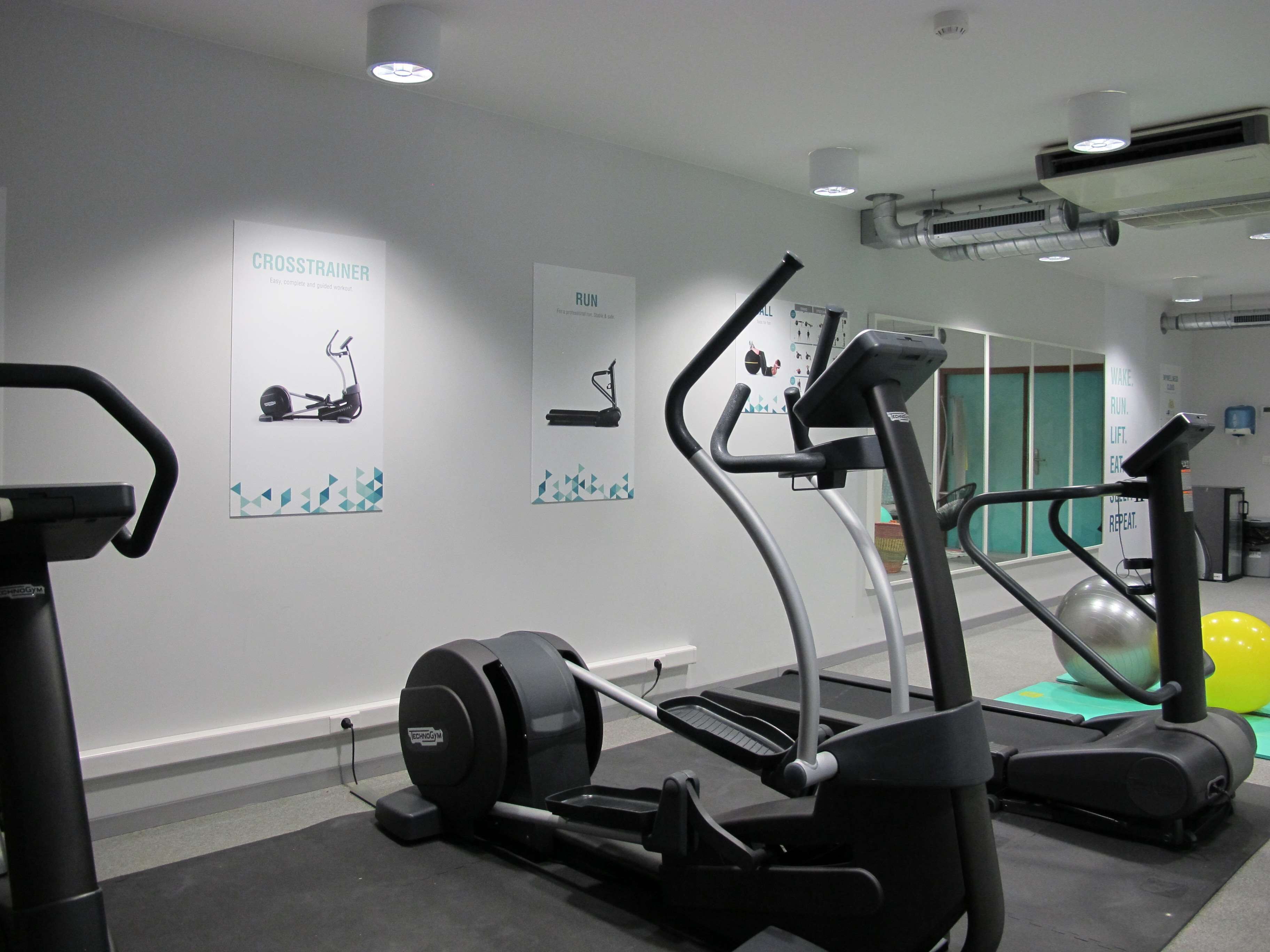 A gym with treadmills, elliptical machines, and a stationary bike.