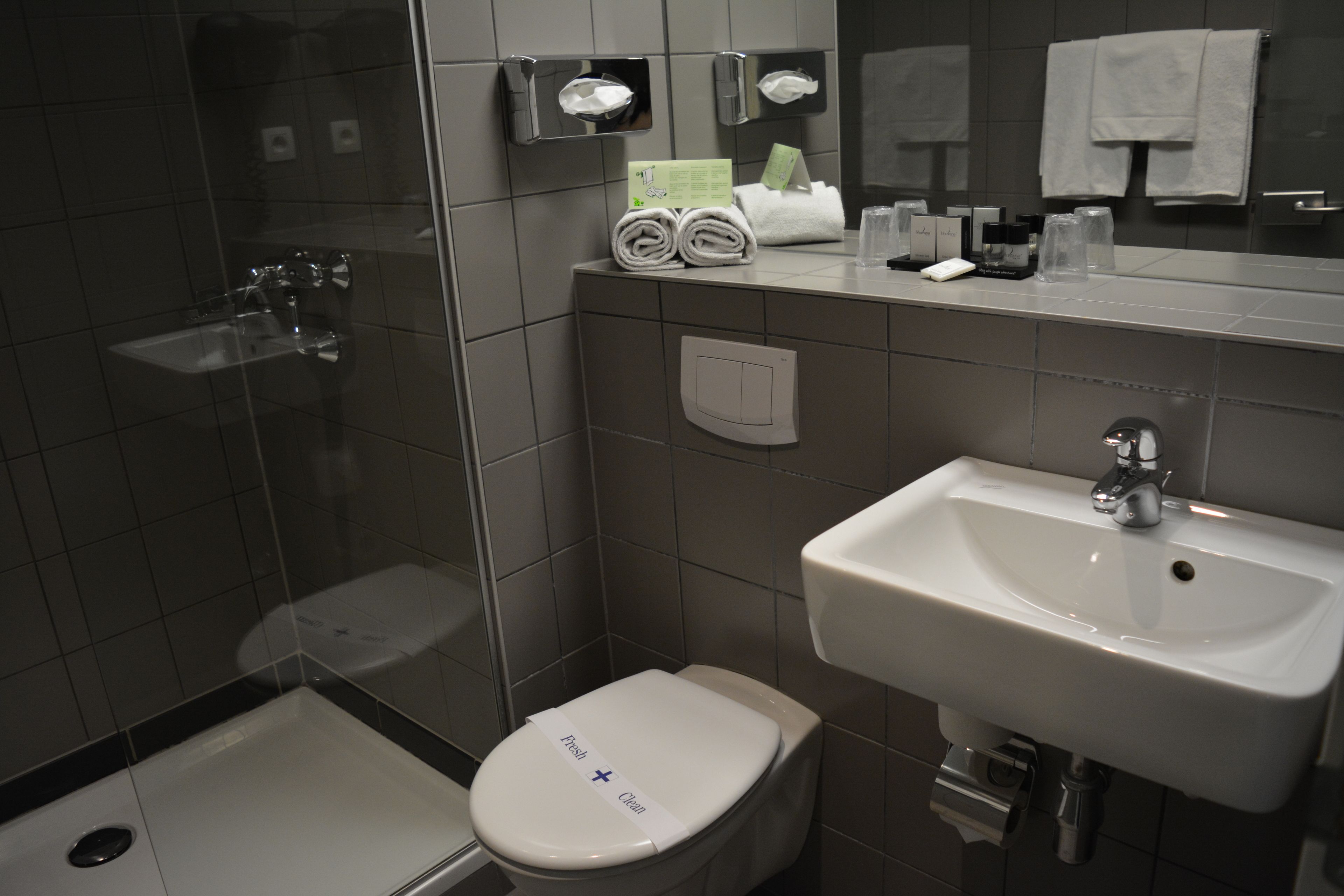 Un baño moderno con inodoro, lavamanos y ducha.