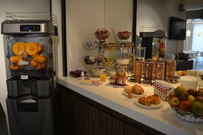 A buffet setup with various food items and a beverage dispenser. - Best Western Hotel Brussels South (Sint-Pieters-Leeuw)