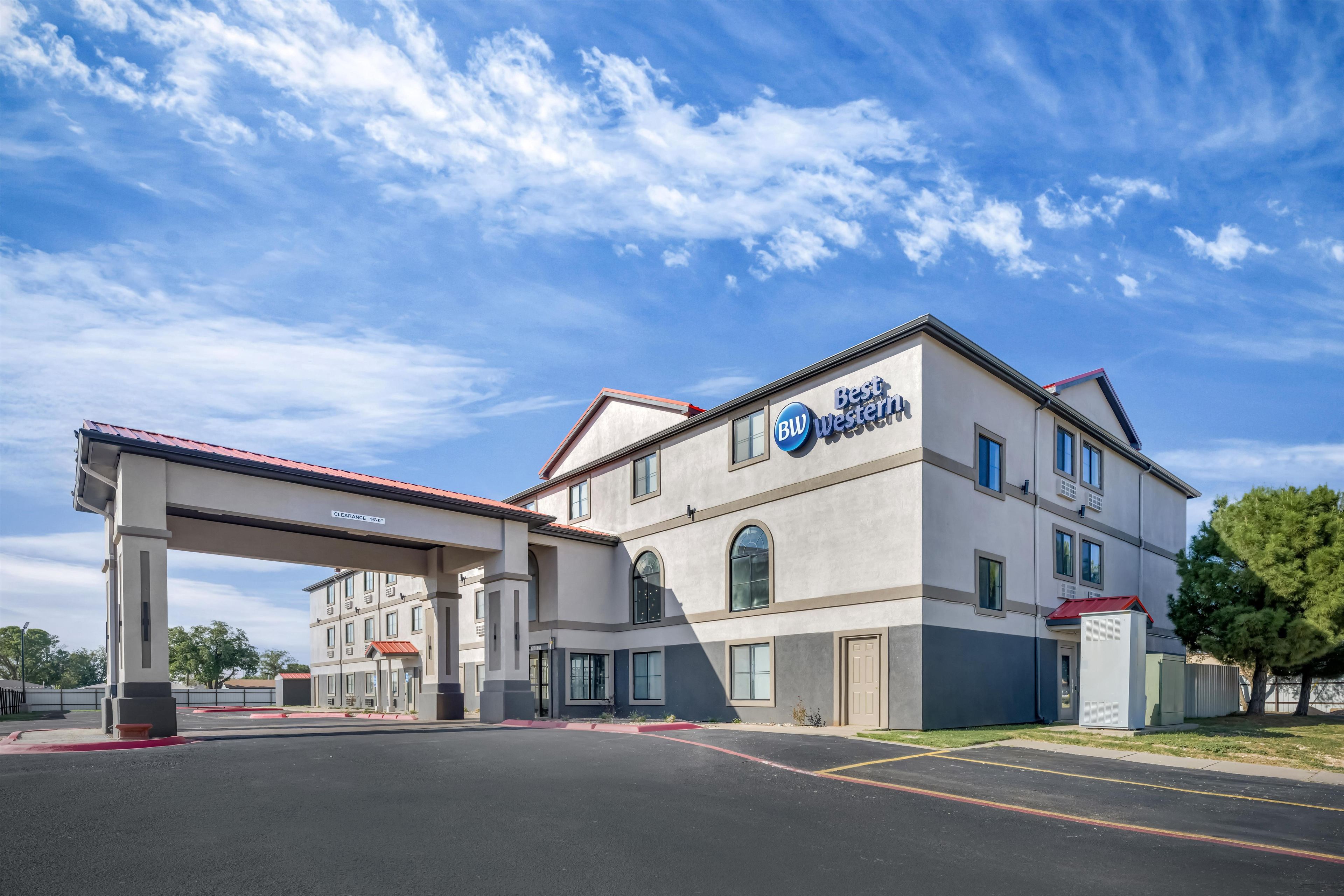 Un hôtel Best Western offrant une vue sur un ciel dégagé, un parking couvert et un panneau indiquant une hauteur libre de 16 pieds.