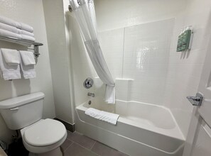 Un baño con inodoro, bañera y cortina de ducha.