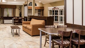 A spacious living area with a sofa, dining table, chairs, and a small coffee table. - Microtel Inn & Suites by Wyndham Wheeler Ridge (Arvin)
