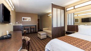 A hotel room with a bed, a desk, a chair, a sofa, a TV, and a bathroom. - Microtel Inn & Suites by Wyndham Wheeler Ridge (Arvin)