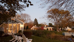 A residential area with houses, a lawn, and outdoor seating. - The Cottages at Cabot Cove (Kennebunkport)